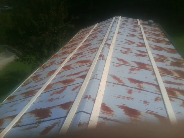 Rusted metal roof panels with new wood purlins before replacement — Storm Damage Roof Repair in Westmoreland by Roofing Brothers